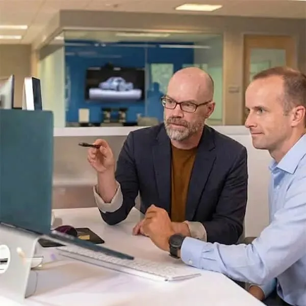 Mitch showing Ross the progress hes made with a software application that they're working on.